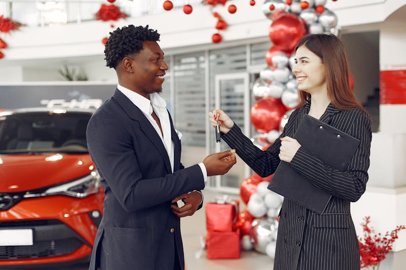 Happy couple receiving car keys at a dealership