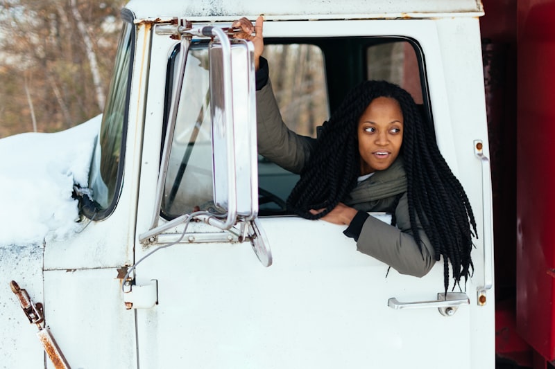 Female truck driver looking out of a white semi truck
